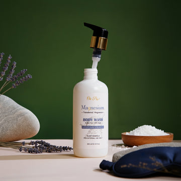 Body wash bottle with pump on a wooden surface with lavender and stones in the background Body wash bottle with pump on a wooden surface with lavender and stones in the background