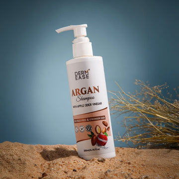 Derm Ease Argan Shampoo bottle on sand with a blurred natural background Derm Ease Argan Shampoo bottle on sand with a blurred natural background